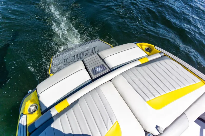 Slide: The Image of 2016 Malibu 24.5 MKZ boat with yellow and white seating on water. - 26