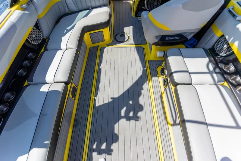 Slide: The Image of 2016 Malibu 24.5 MKZ boat interior with yellow accents and spacious seating. - 27