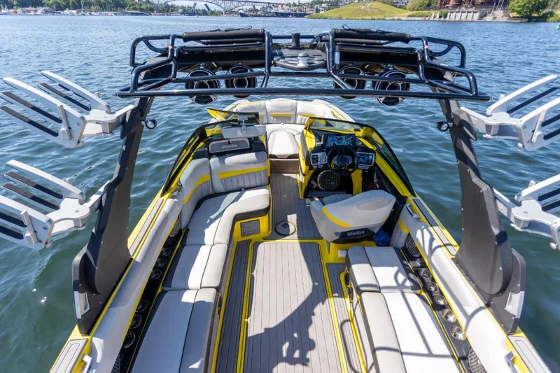 Slide: The Image of 2016 Malibu 24.5 MKZ boat interior with sleek design and advanced controls on a sunny day. - 34