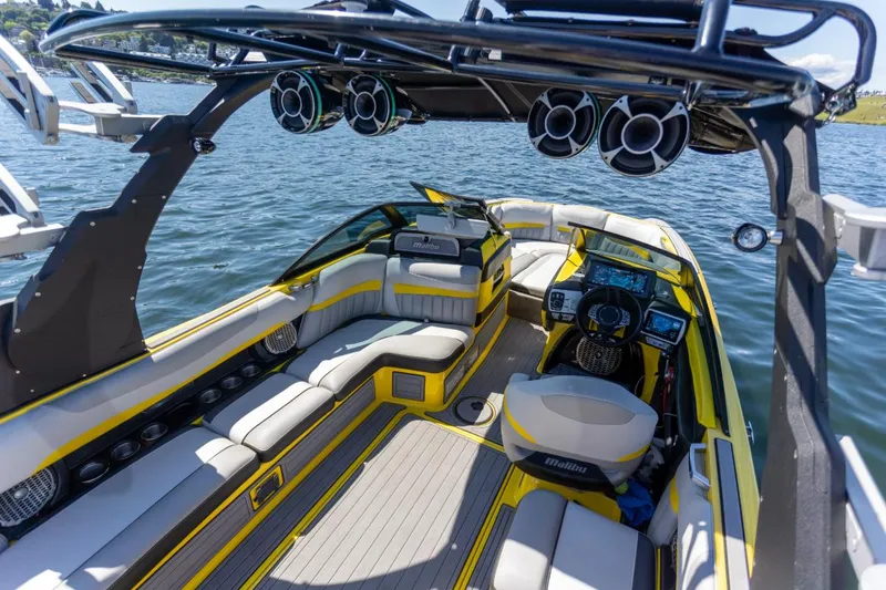 Slide: The Image of 2016 Malibu 24.5 MKZ boat interior with yellow accents on a lake. - 35
