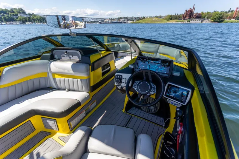 Slide: The Image of 2016 Malibu 24.5 MKZ boat interior with yellow accents on a sunny lake. - 5