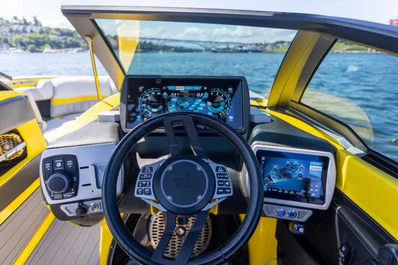 Slide: The Image of 2016 Malibu 24.5 MKZ boat dashboard with advanced controls and digital displays on the water. - 6