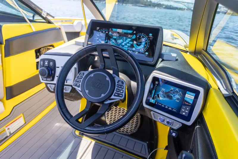 Slide: The Image of 2016 Malibu 24.5 MKZ boat dashboard with advanced digital controls and steering wheel. - 7
