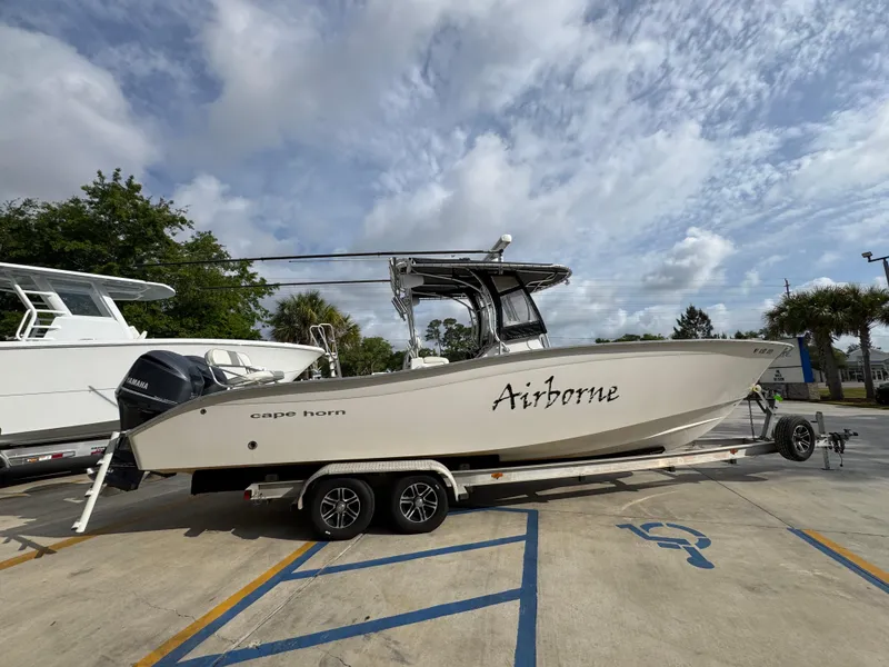 Slide: The Image of 2006 Cape Horn 31 T boat on trailer, labeled "Airborne," parked outdoors under cloudy sky. - 10