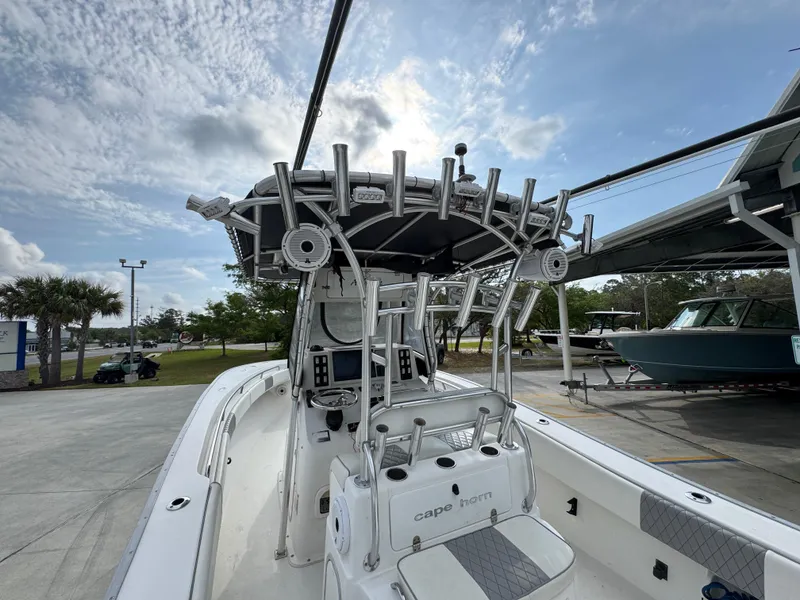 Slide: The Image of 2006 Cape Horn 31 T boat with T-top and rod holders, parked outdoors under a cloudy sky. - 31