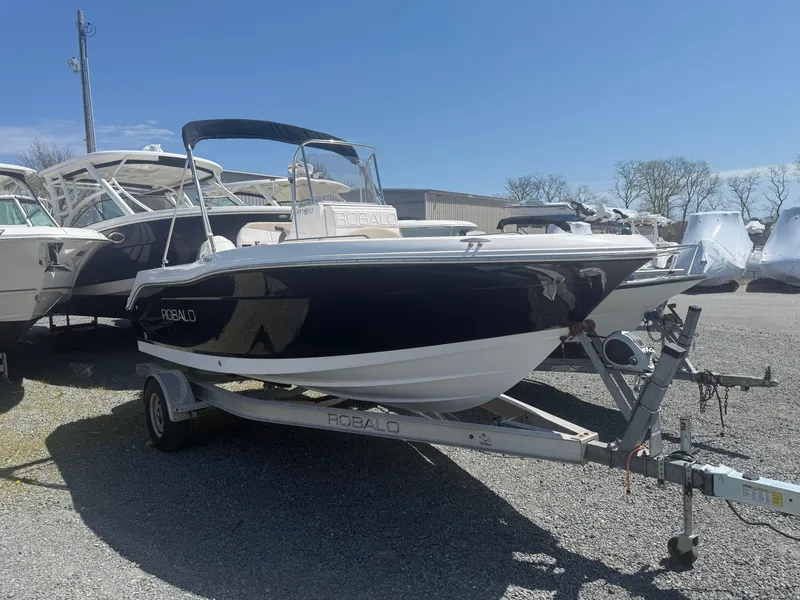 Slide: The Image of 2018 Robalo R180 Center Console boat on trailer, parked outdoors under clear sky. - 3
