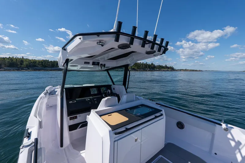 Slide: The Image of 2025 Axopar CCX Center Console boat on calm water under blue sky. - 10