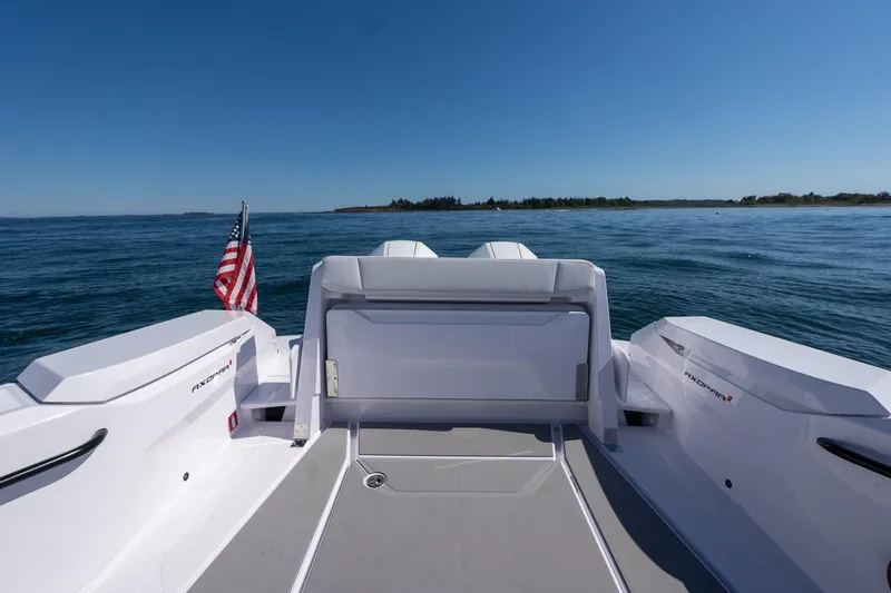 Slide: The Image of 2025 Axopar CCX Center Console boat interior with seating, cup holder, and ocean view. - 15