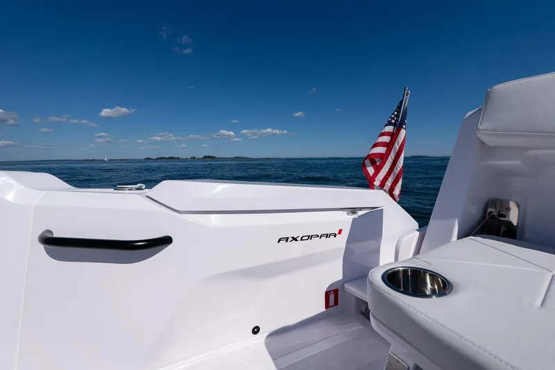 Slide: The Image of 2025 Axopar CCX Center Console boat on open water, featuring sleek design and American flag. - 16