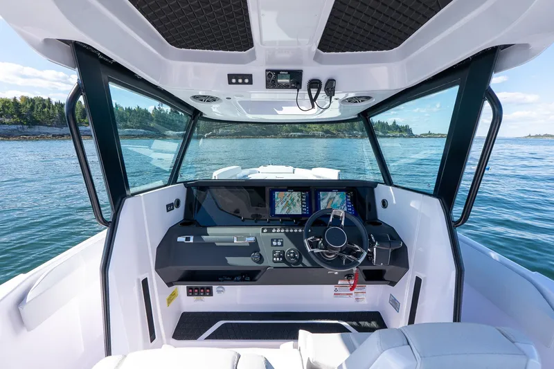 Slide: The Image of 2025 Axopar CCX Center Console boat on calm water, featuring modern helm and seating. - 21