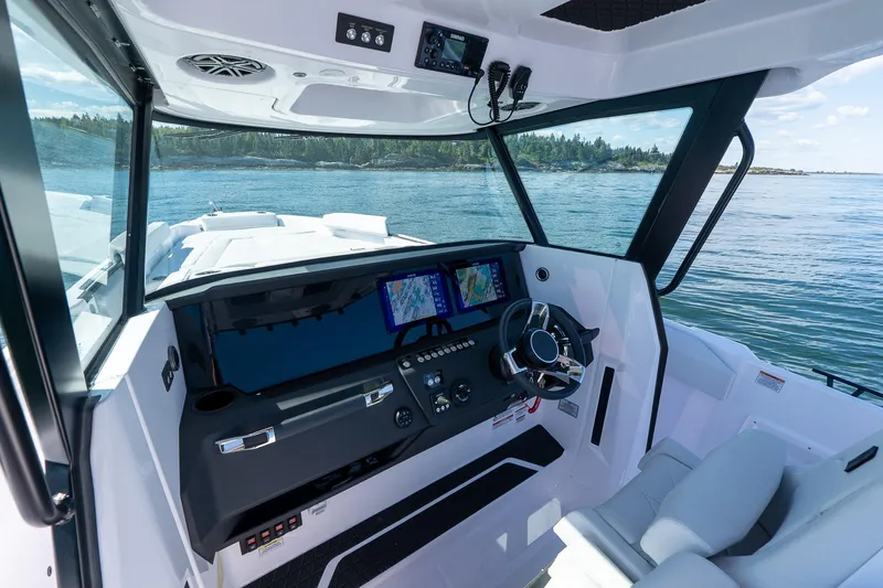 Slide: The Image of 2025 Axopar CCX Center Console boat interior with advanced navigation system on a scenic waterway. - 22