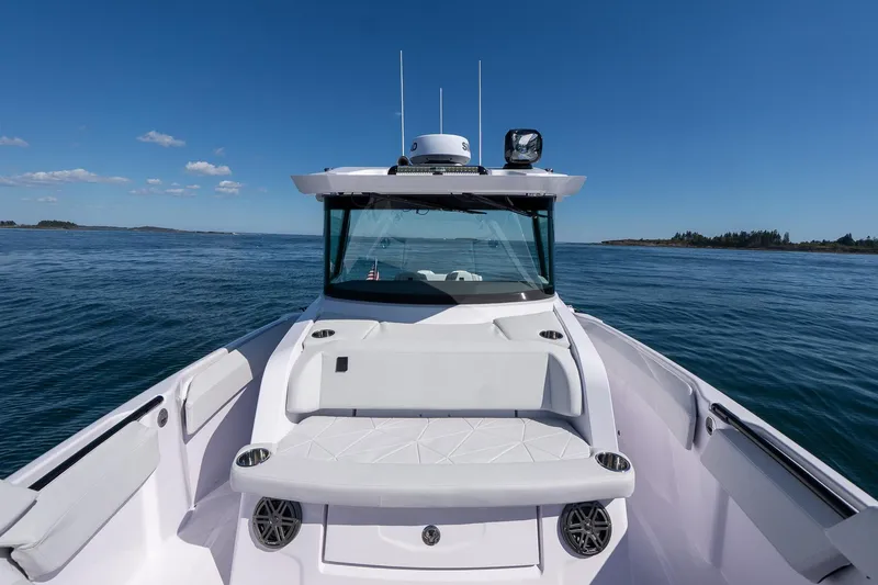 Slide: The Image of 2025 Axopar CCX Center Console boat on calm water under blue sky. - 33