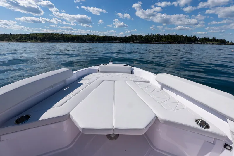 Slide: The Image of 2025 Axopar CCX Center Console boat on calm ocean waters under clear blue sky. - 34
