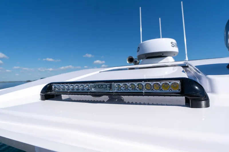 Slide: The Image of 2025 Axopar CCX Center Console boat cruising on a sunny day, scenic water view. - 38