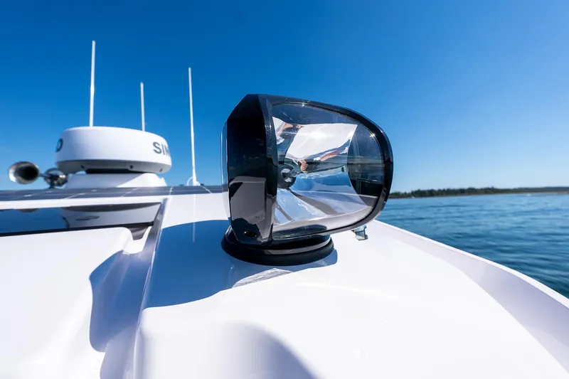 Slide: The Image of 2025 Axopar CCX Center Console boat spotlight on deck, clear blue sky background. - 41