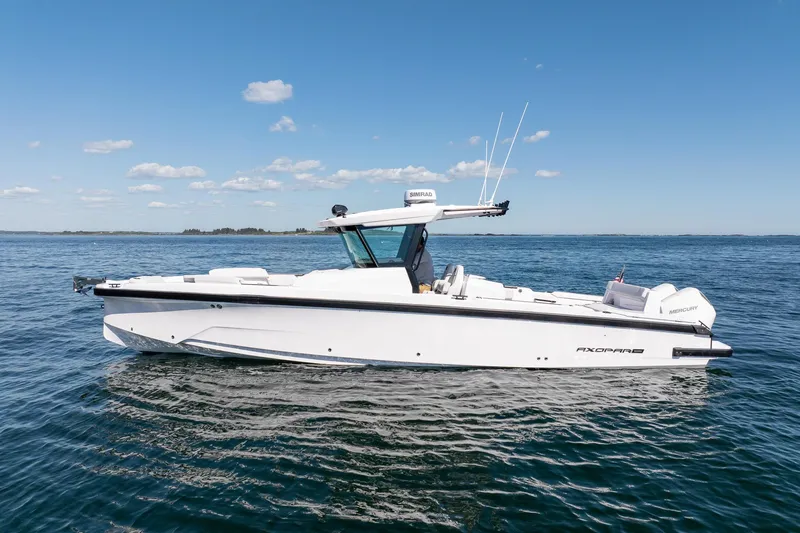 Slide: The Image of 2025 Axopar CCX Center Console boat cruising on a scenic lake. - 6