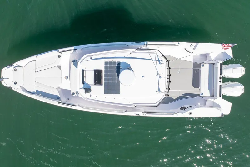Slide: The Image of 2025 Axopar CCX Center Console boat on calm blue water under clear sky. - 7