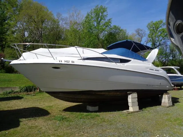 Slide: The Image of 2002 Bayliner 2855 Ciera boat on blocks, outdoors, with blue canopy. - 0