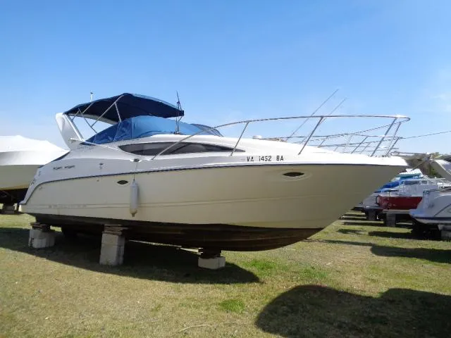 Slide: The Image of 2002 Bayliner 2855 Ciera boat on stands, blue canopy, parked on grass. - 1