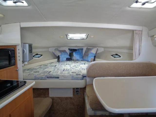 Slide: The Image of Interior of 2002 Bayliner 2855 Ciera boat with cozy sleeping area and dining space. - 14