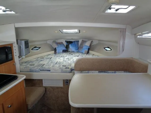 Slide: The Image of Interior of 2002 Bayliner 2855 Ciera with bed, table, and compact kitchen area. - 15