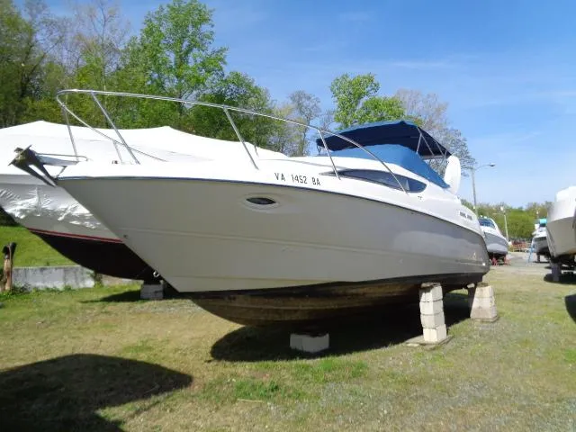 Slide: The Image of 2002 Bayliner 2855 Ciera boat on stands, outdoors, with trees in background. - 2