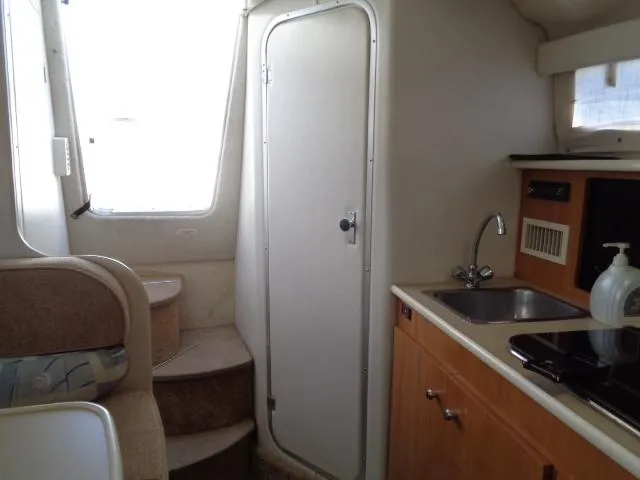 Slide: The Image of Interior of 2002 Bayliner 2855 Ciera boat, featuring kitchenette and cabin door. - 20