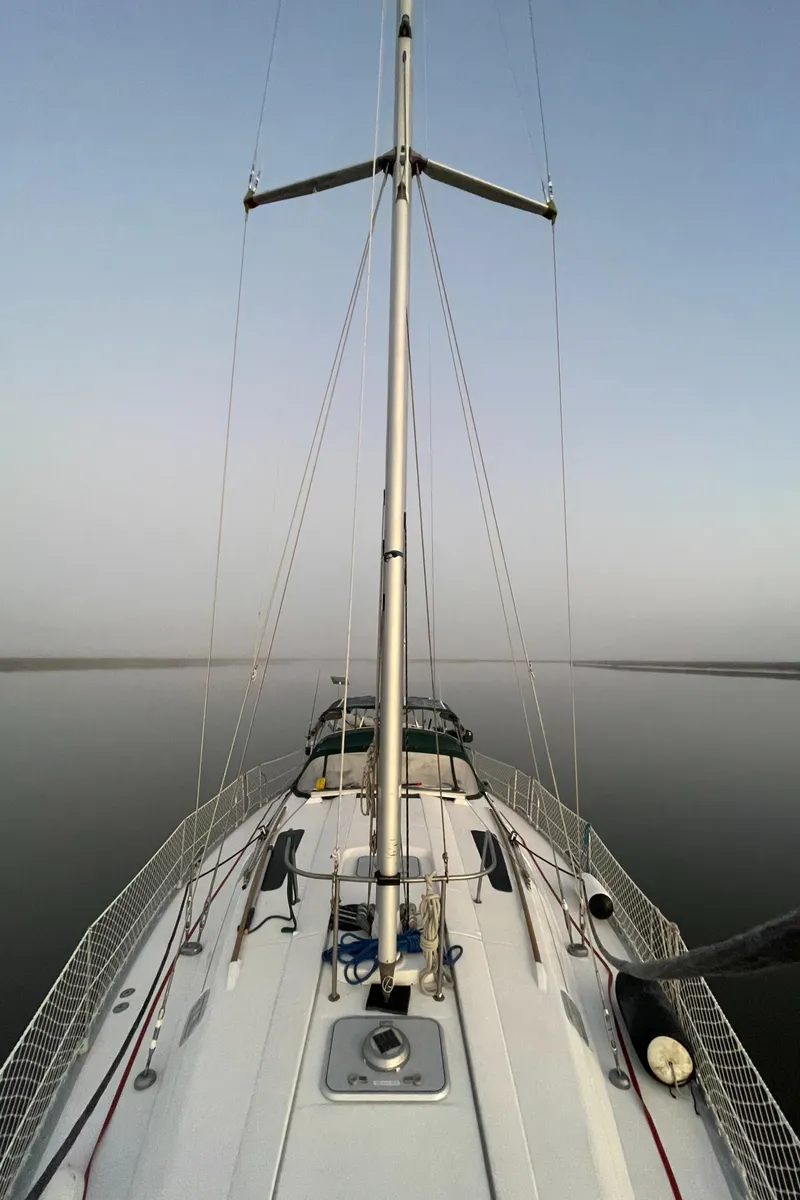 Slide: The Image of 1994 Beneteau Oceanis 440 sailboat on calm water, viewed from the deck. - 1