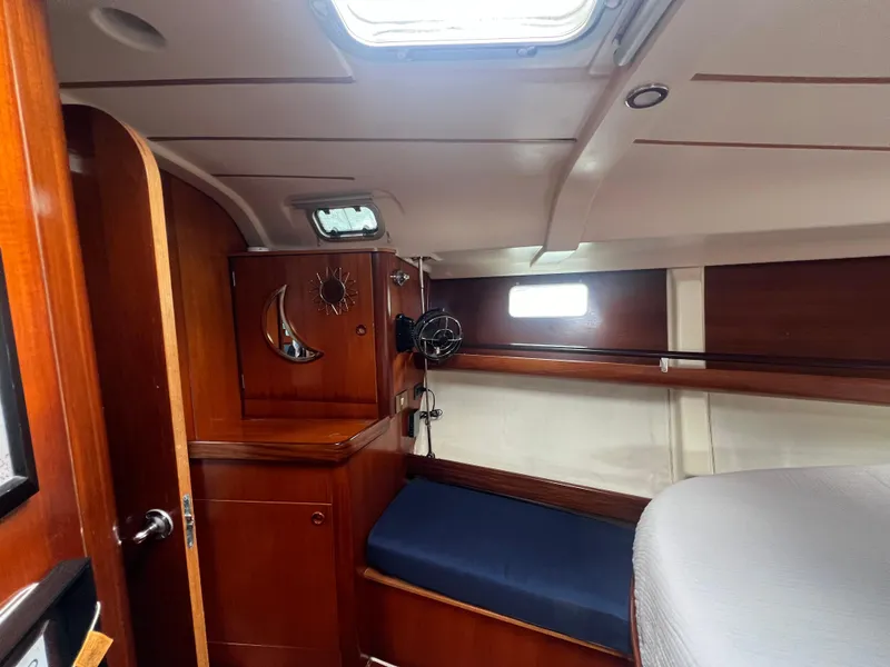 Slide: The Image of Interior cabin of 1994 Beneteau Oceanis 440 sailboat with wooden finish and blue seating. - 10