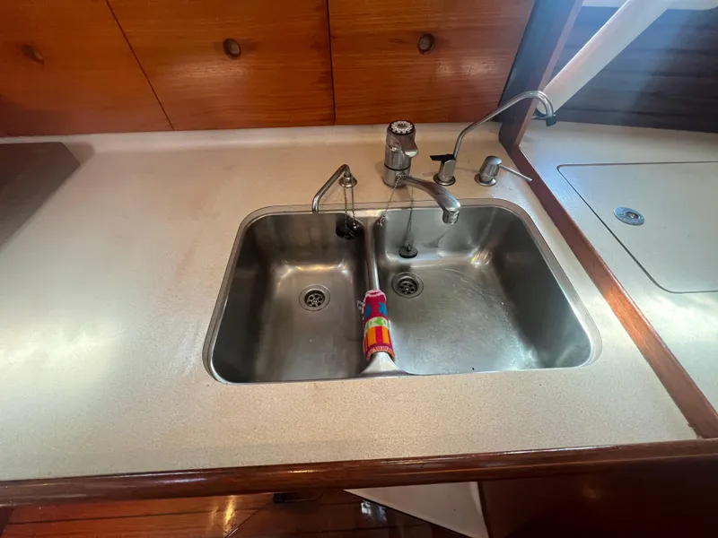 Slide: The Image of Galley sink in 1994 Beneteau Oceanis 440 yacht with dual basins and wooden cabinetry. - 14