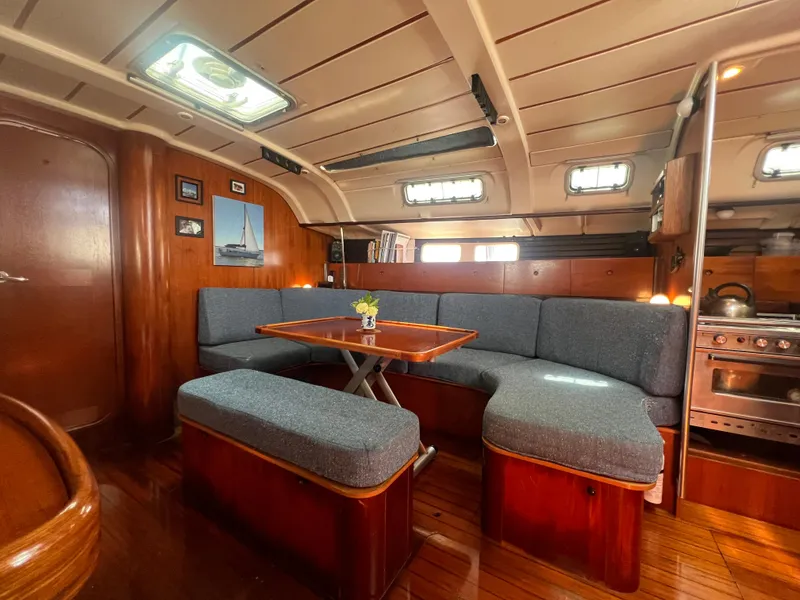 Slide: The Image of Interior of 1994 Beneteau Oceanis 440 sailboat with cozy seating and wooden finishes. - 16