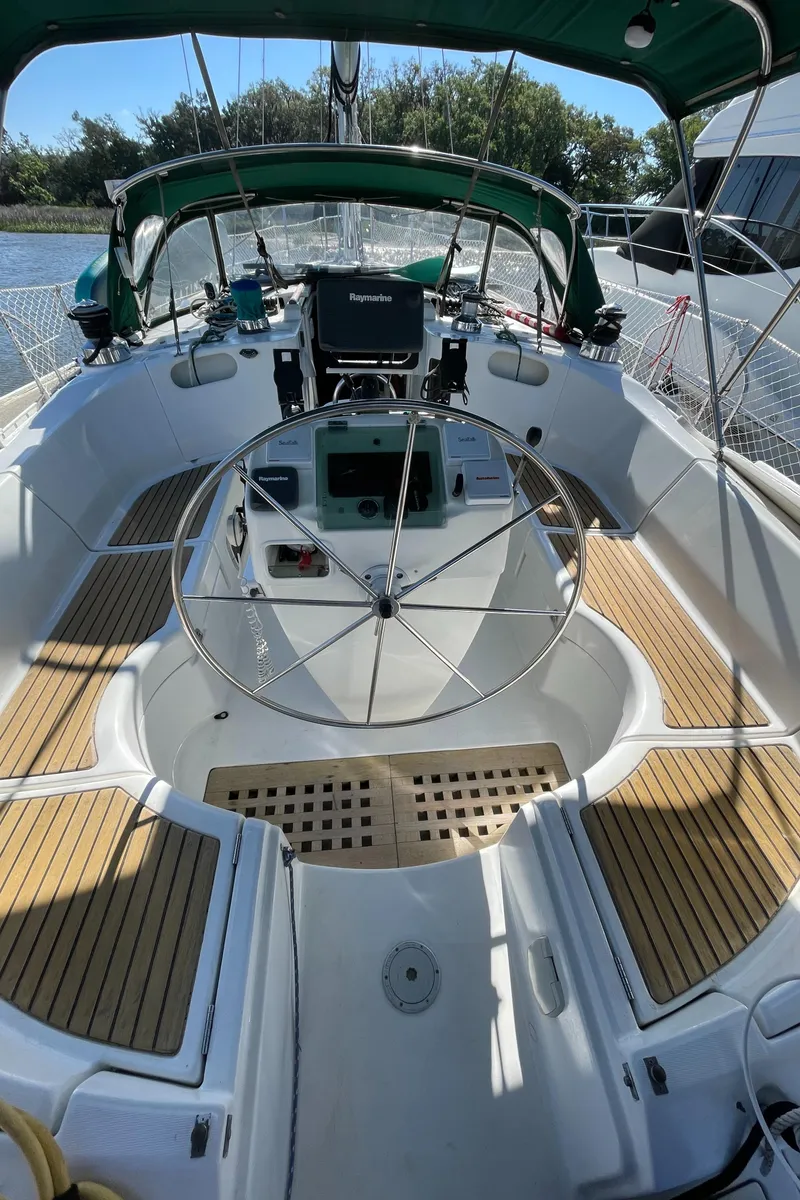 Slide: The Image of Cockpit of 1994 Beneteau Oceanis 440 sailboat with wooden deck and steering wheel. - 34