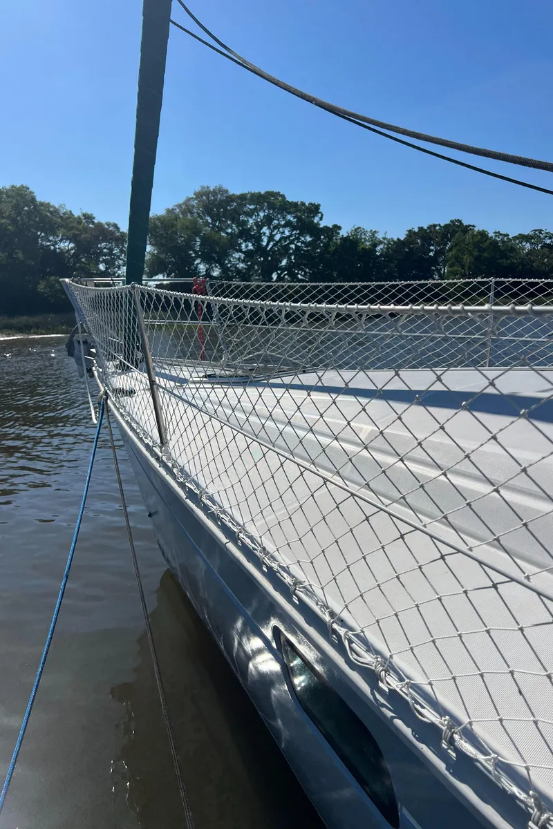 Slide: The Image of 1994 Beneteau Oceanis 440 sailboat docked, featuring deck netting and clear blue sky. - 4