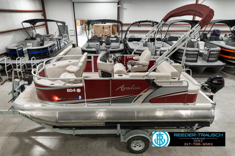 Slide: The Image of 2019 Avalon Eagle pontoon boat in showroom, featuring red and silver design. - 1