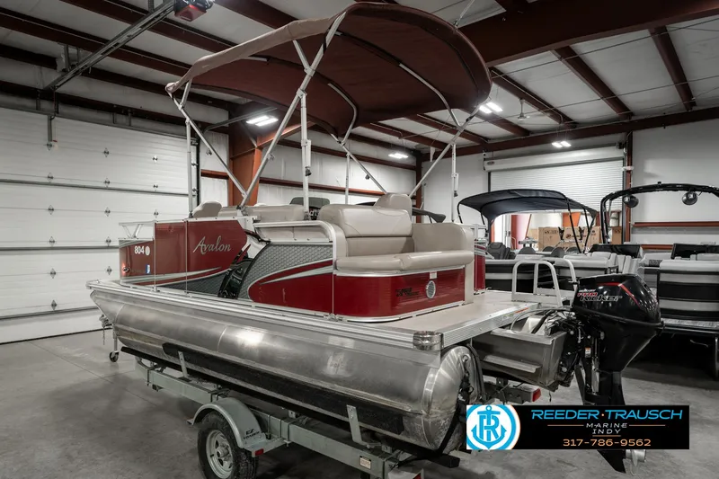 Slide: The Image of 2019 Avalon Eagle pontoon boat in a showroom, featuring a red and silver design. - 10