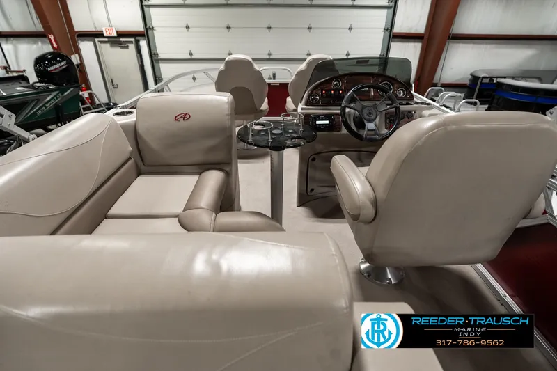 Slide: The Image of 2019 Avalon Eagle boat interior with beige seating and steering console in a showroom. - 18