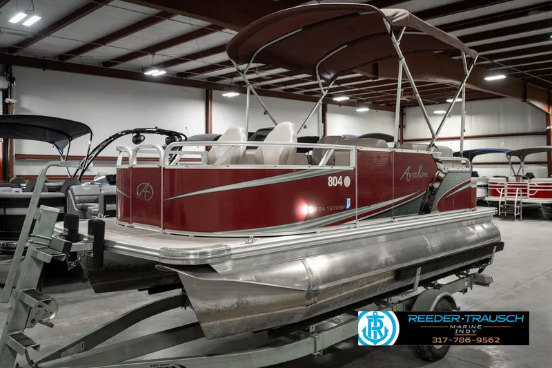 Slide: The Image of 2019 Avalon Eagle pontoon boat in showroom, featuring red exterior and canopy. - 3
