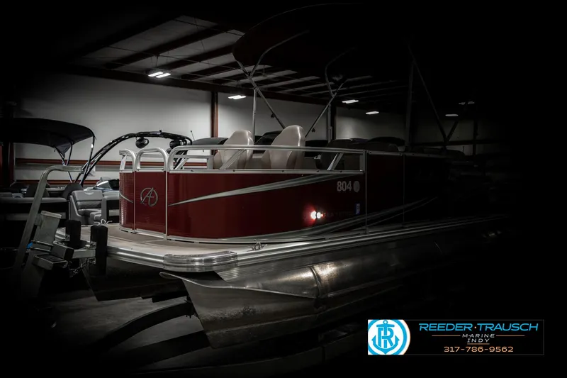 Slide: The Image of 2019 Avalon Eagle pontoon boat in a dimly lit indoor storage facility. - 4