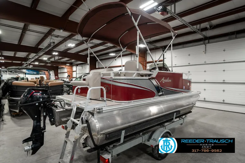 Slide: The Image of 2019 Avalon Eagle pontoon boat in showroom with canopy and motor. - 8