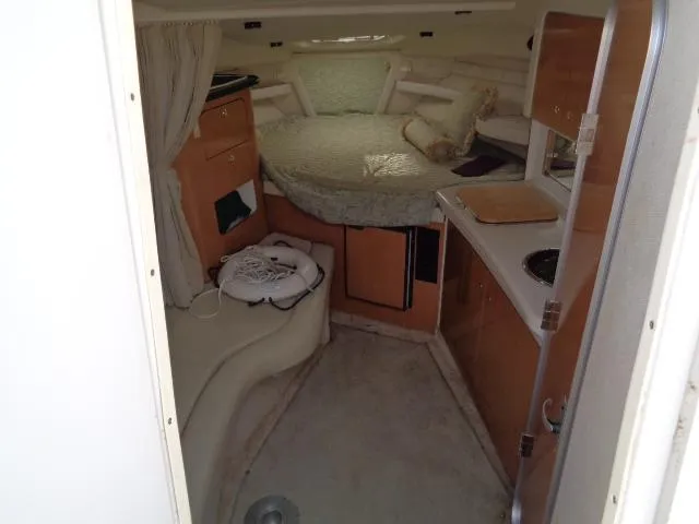 Slide: The Image of Interior of 2001 Regal Commodore 2760 boat, featuring cozy cabin with bed and kitchenette. - 16