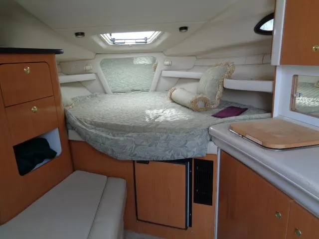 Slide: The Image of 2001 Regal Commodore 2760 cabin interior with bed, wooden cabinets, and small window. - 17