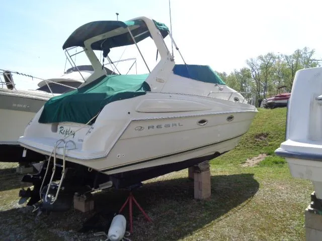 Slide: The Image of 2001 Regal Commodore 2760 boat on land with green cover and canopy. - 3