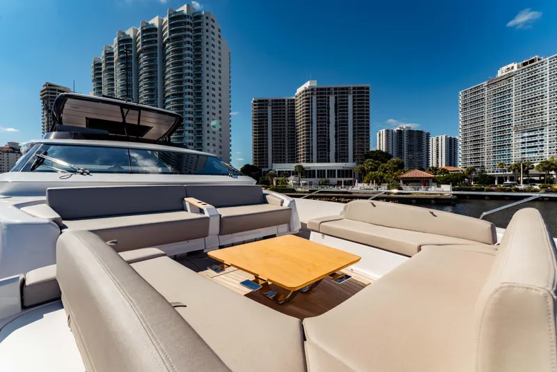 Slide: The Image of 2023 Ferretti Yachts 860 with luxurious seating, city skyline backdrop. - 11