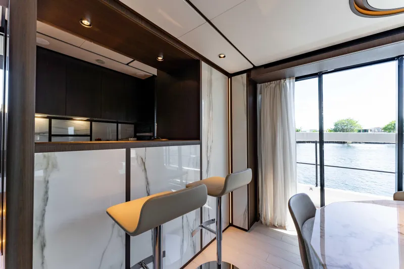 Slide: The Image of Luxurious interior of 2023 Ferretti Yachts 860 with modern bar stools and panoramic window view. - 44