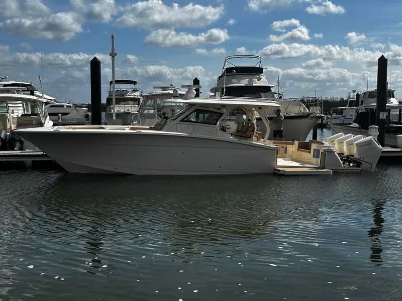 Slide: The Image of 2025 Scout 400 LXF boat docked in marina under cloudy sky. - 0