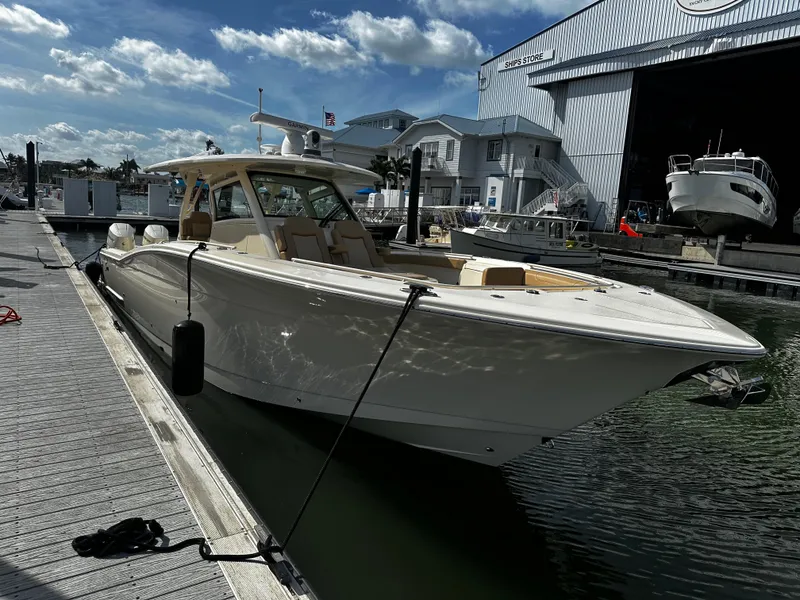 Slide: The Image of 2025 Scout 400 LXF boat docked at marina with clear skies. - 14