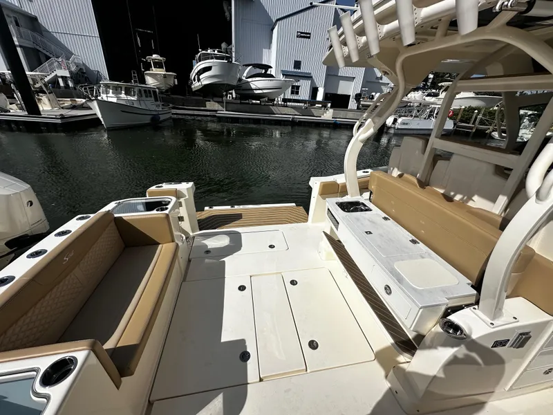 Slide: The Image of 2025 Scout 400 LXF boat interior with beige seating, docked at a marina. - 16
