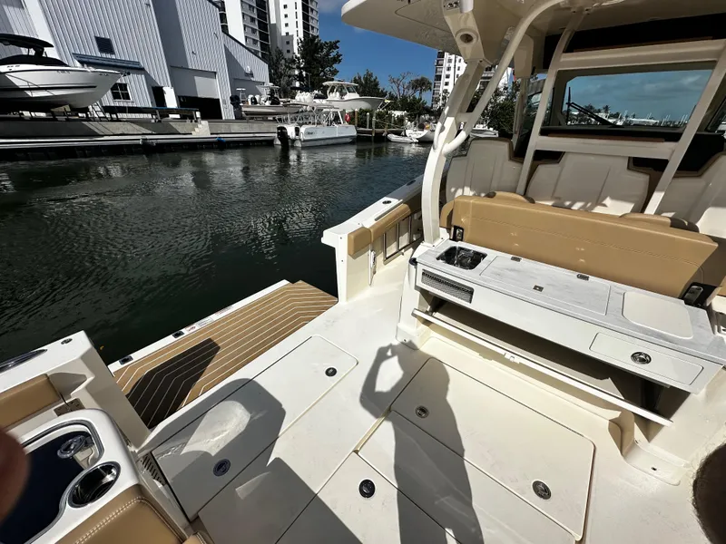 Slide: The Image of 2025 Scout 400 LXF boat interior at marina, featuring seating and storage. - 17