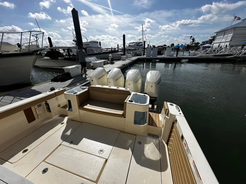 Slide: The Image of 2025 Scout 400 LXF boat docked at marina, featuring four powerful outboard engines. - 18