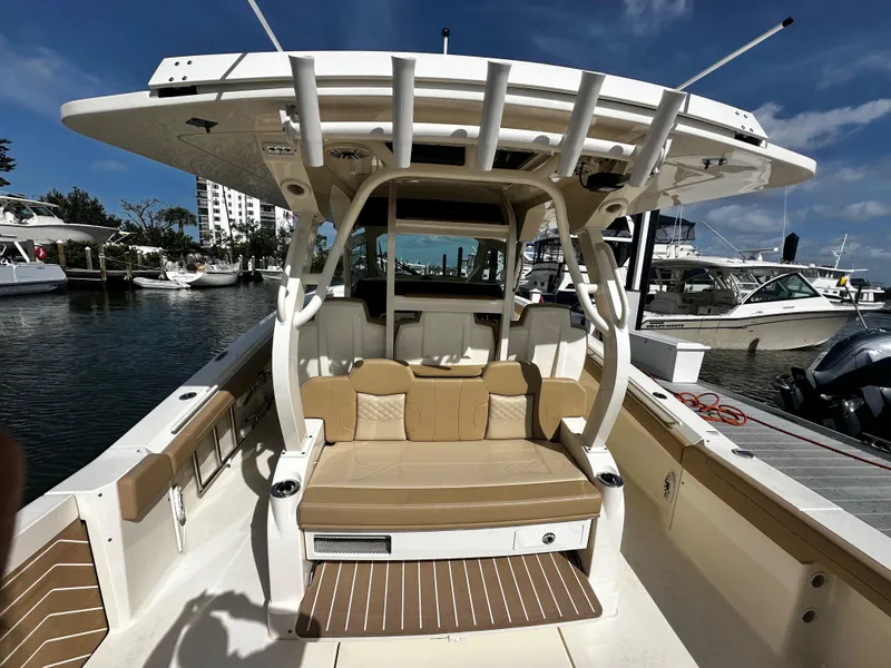 Slide: The Image of 2025 Scout 400 LXF boat interior with seating, docked at marina under clear sky. - 19